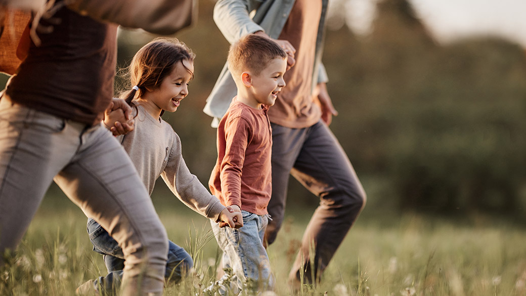 A family with children walking through a pasture.